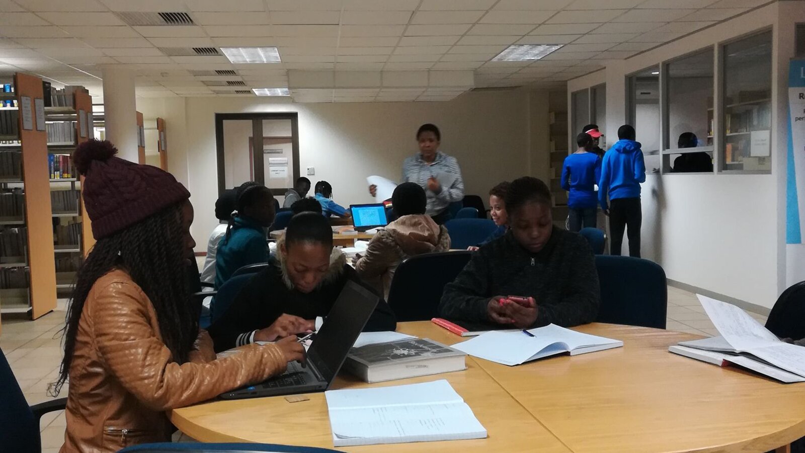 Estudiantes investigando en una biblioteca universitaria